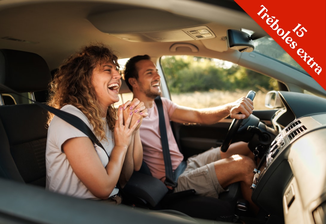 Hombre y mujer en coche de alquiler Enterprise felices por el descuento de 15 Tréboles del Club MAPFRE