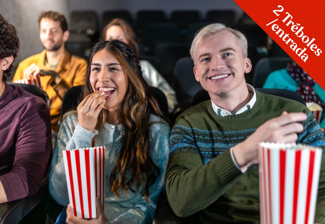 Hija y padre comiendo palomitas en sala de cine. Promoción de 2 Tréboles por entrada de cine.