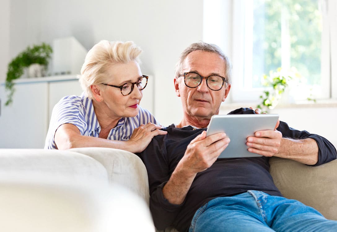 Dos personas mayores consultando cómo horrar en los gastos del hogar