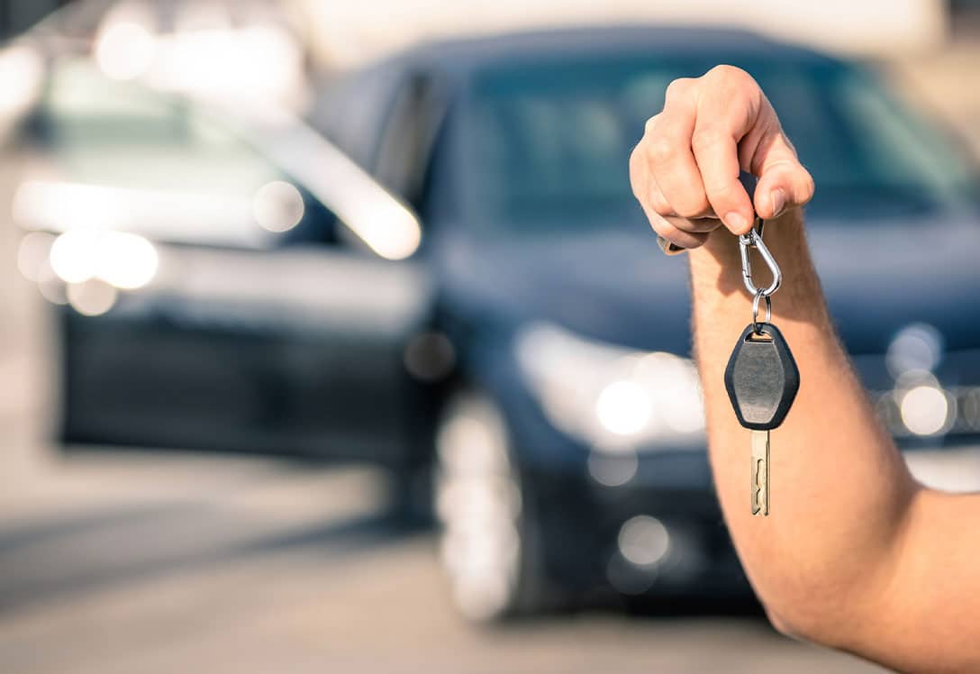 Mano sujetando llaves de la compra de un coche de segunda mano