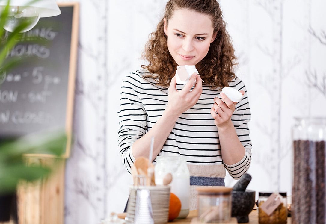 mujer oliendo cosmética natural