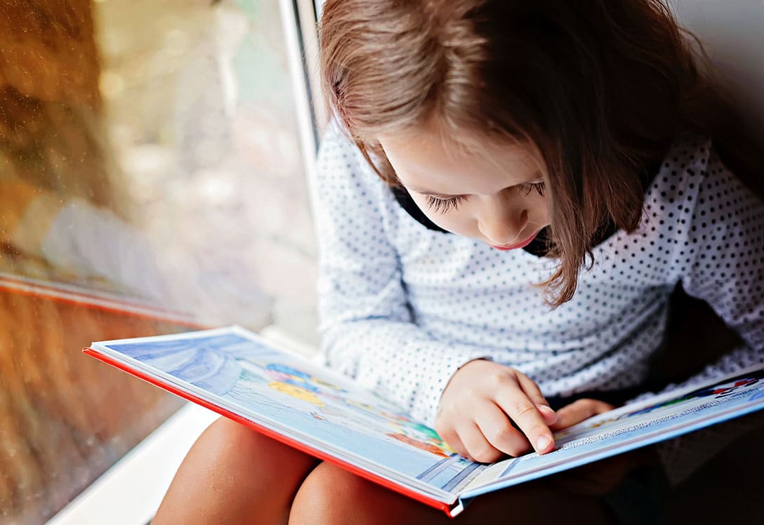 Niña aprendiendo a leer en este curso escolar