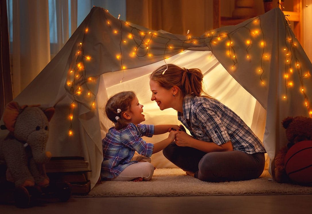 madre e hijo jugando a acampar dentro de casa