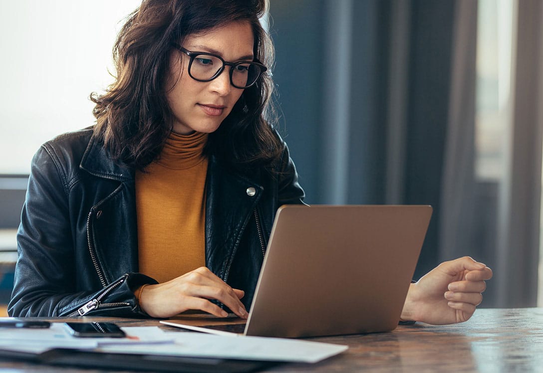 mujer con gafas consultando su portatil