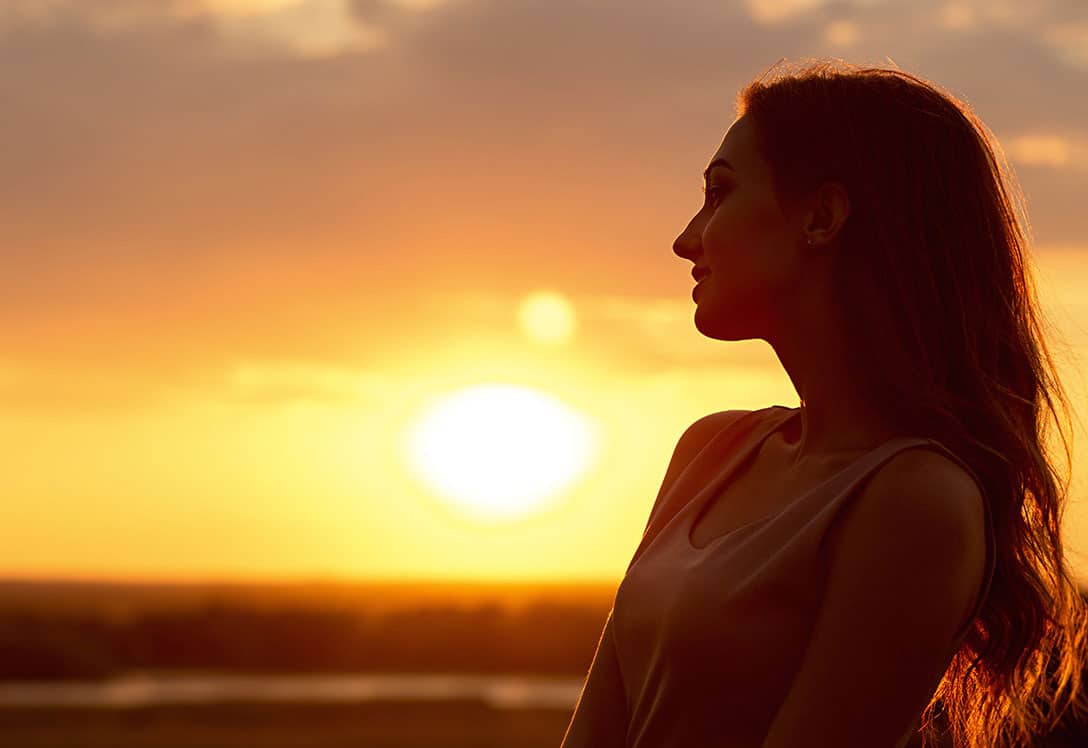 contraluz de perfil de mujer en puesta de sol