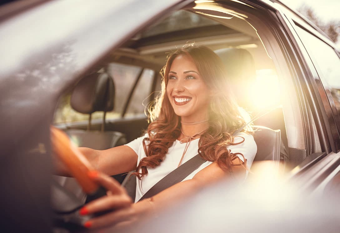 Mujer sonriendo al volante