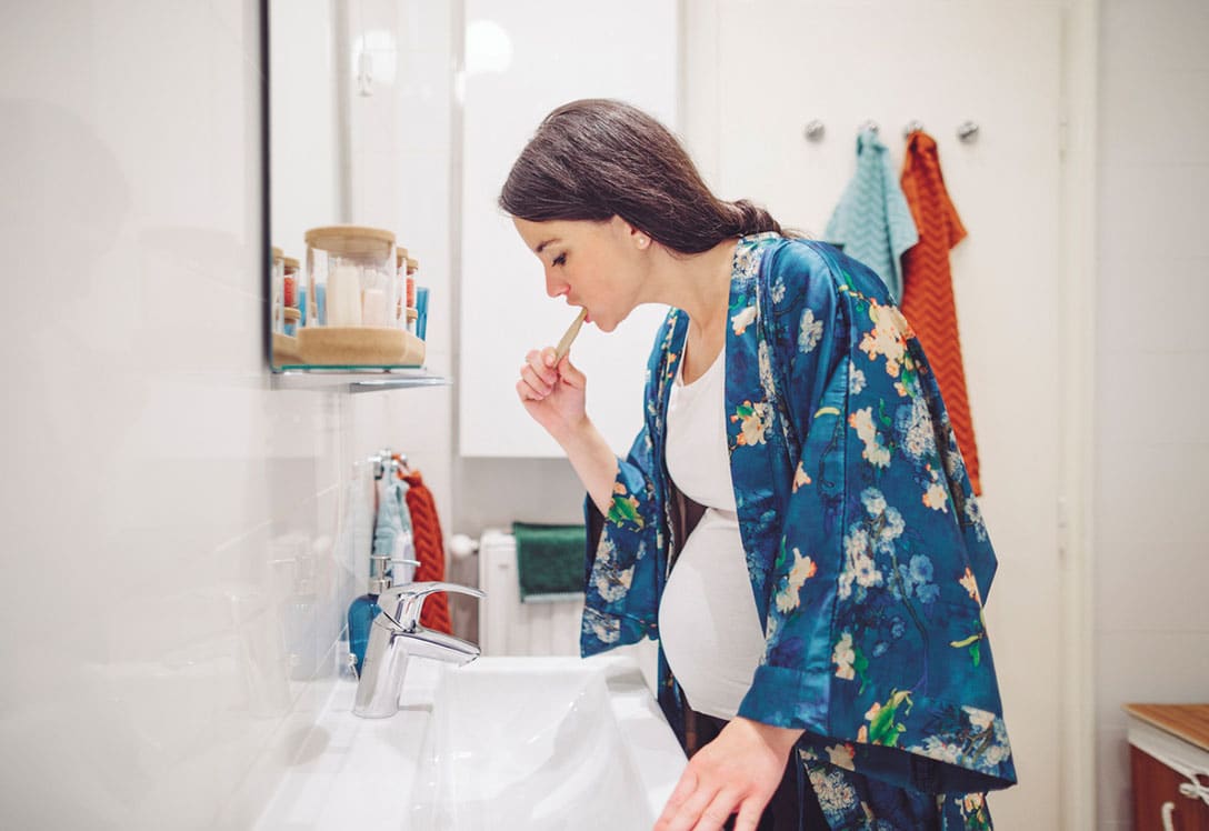 Mujer embarazada lavándose los dientes