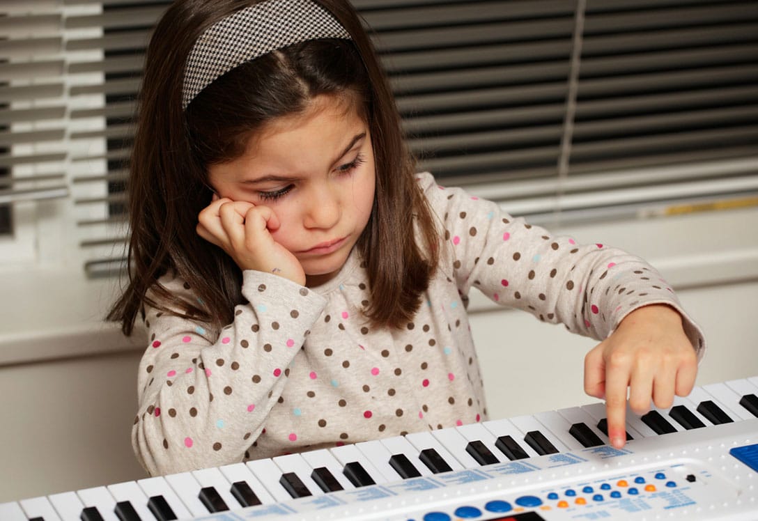 niña aburrida frente a piano