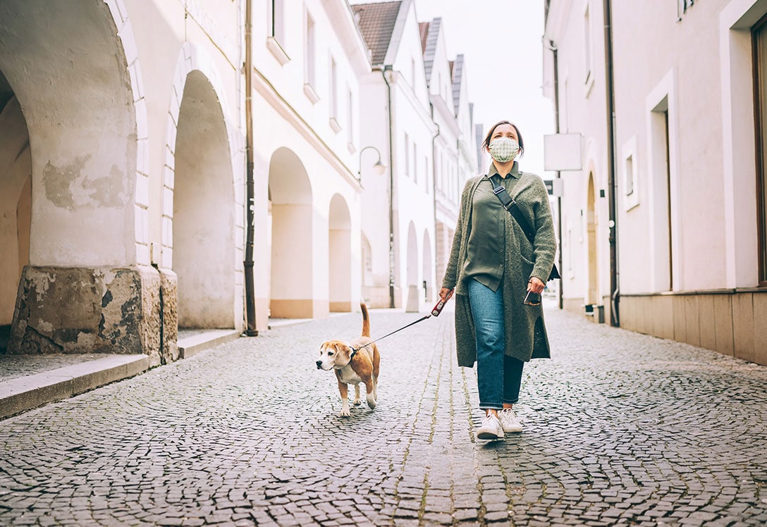 mujer con mascarilla paseado al perro
