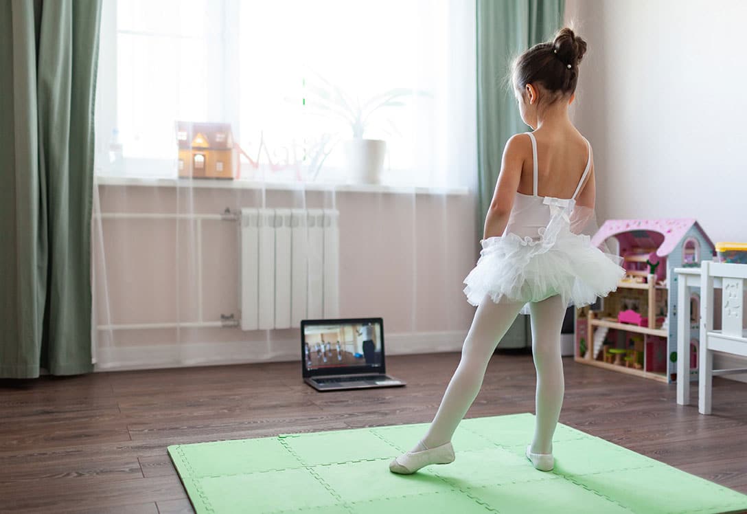 Niña aprendiendo a bailar ballet en casa