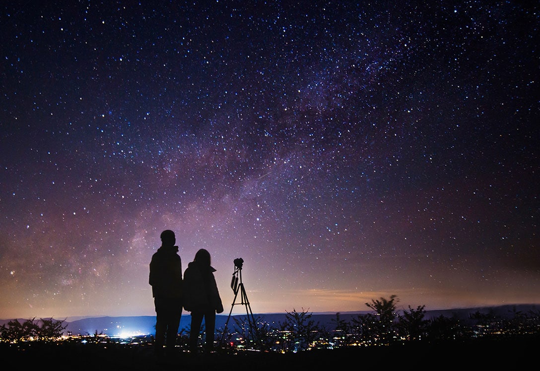 Pareja fotografiando las estrellas en la noche