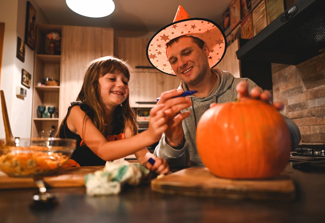 Padre e hija pintan calabaza para Halloween