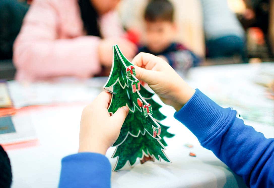 Un niño hace un árbol de navidad