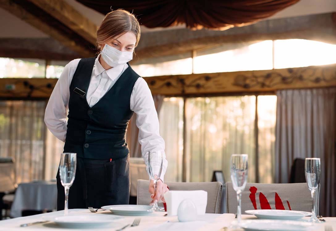 Camarero monta una mesa en un restaurante