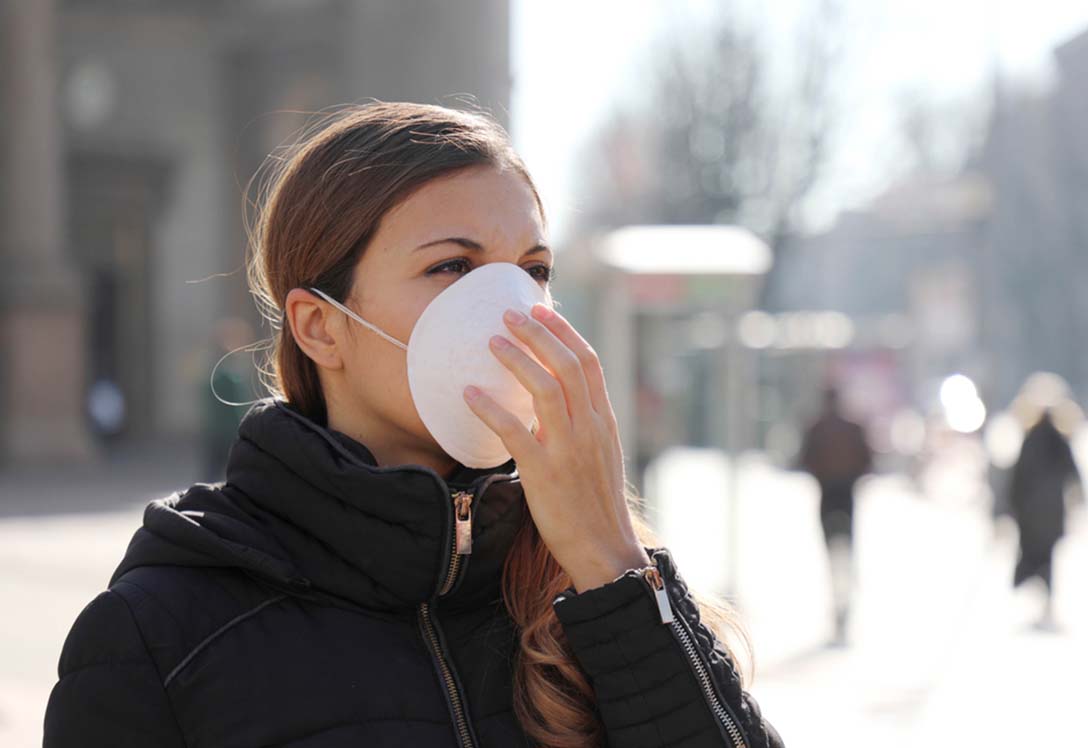 Chica usando una mascarilla en la calle durante la pandemia