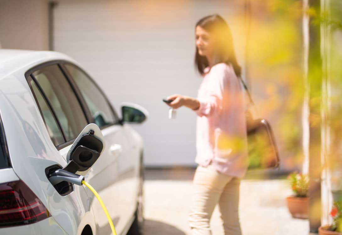 Chica cerrando coche eléctrico