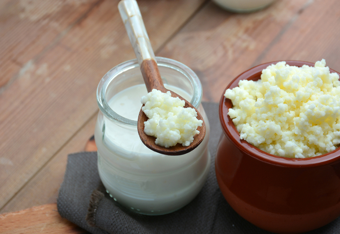 cuchara-bote-kefir cuchara con kéfir sobre bote de lácteo
