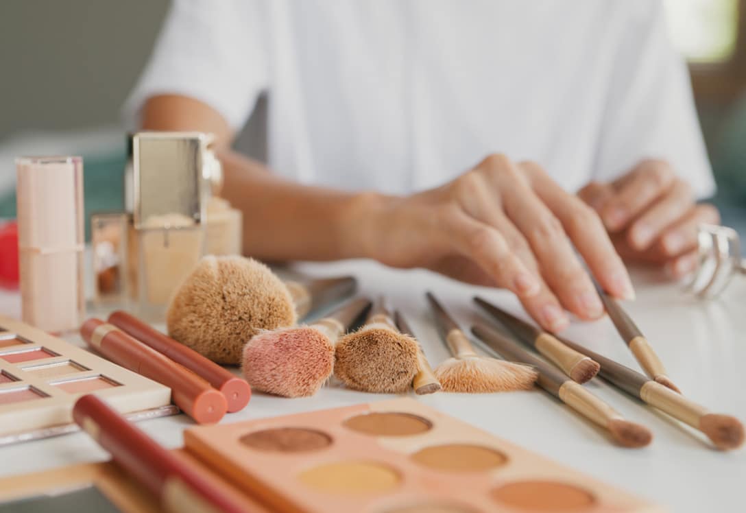 manos jóvenes ordenando maquillaje para su emprendimiento