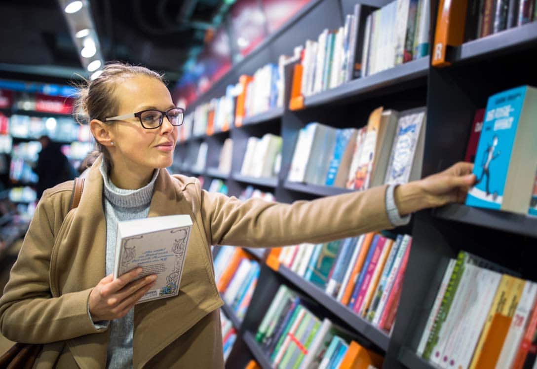 Lectora revisa libros en una biblioteca