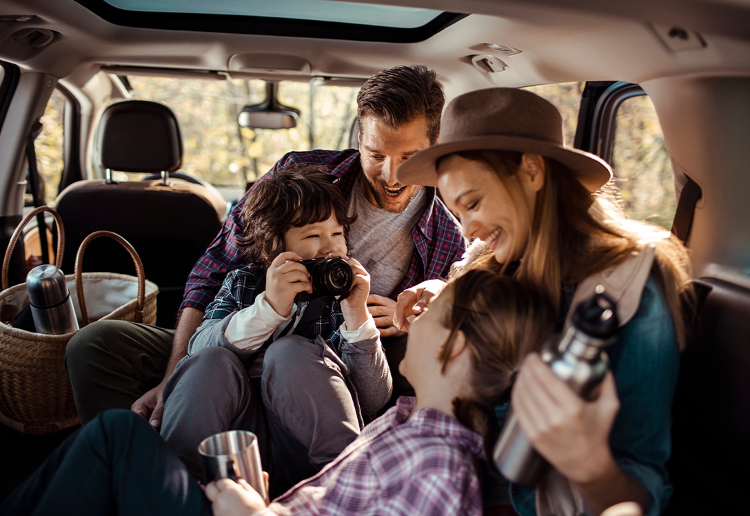 familia disfruta dentro del coche familiar