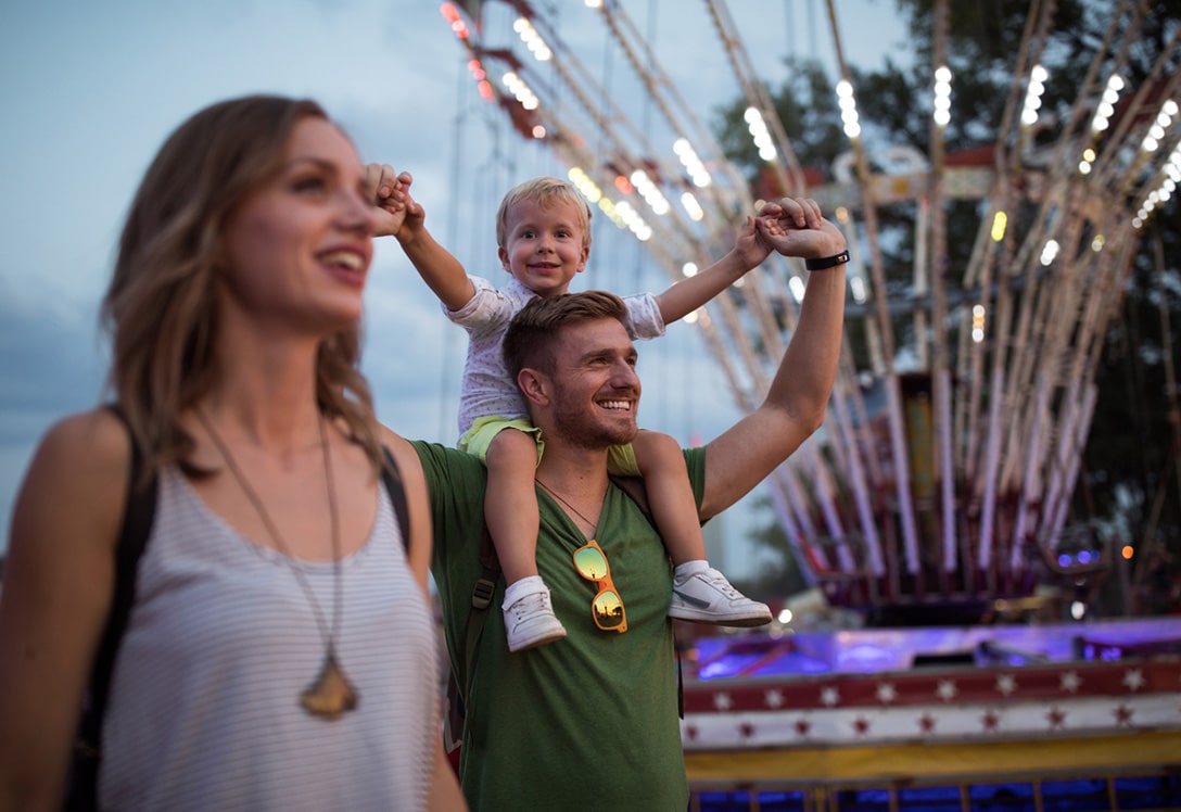 familia joven pasenado por parque de aracciones
