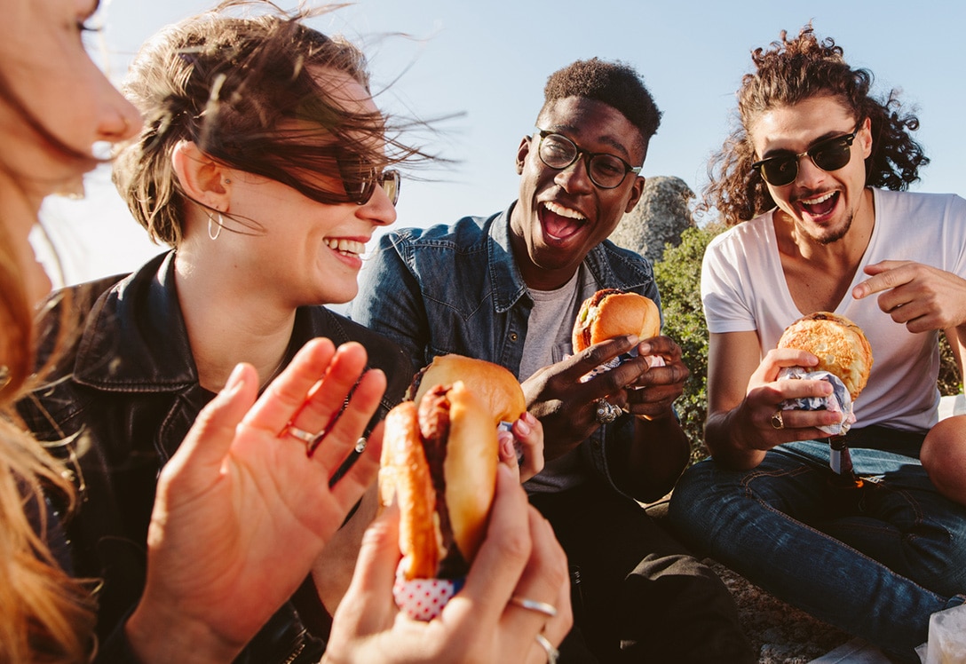 grupo de jóvenes disfrutando de comida rápida al aire libre