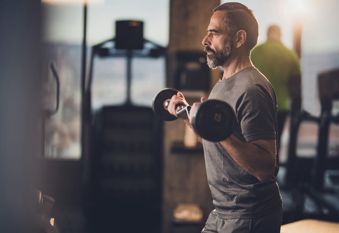 hombre ejercicio de pesas para mejorar artrosis