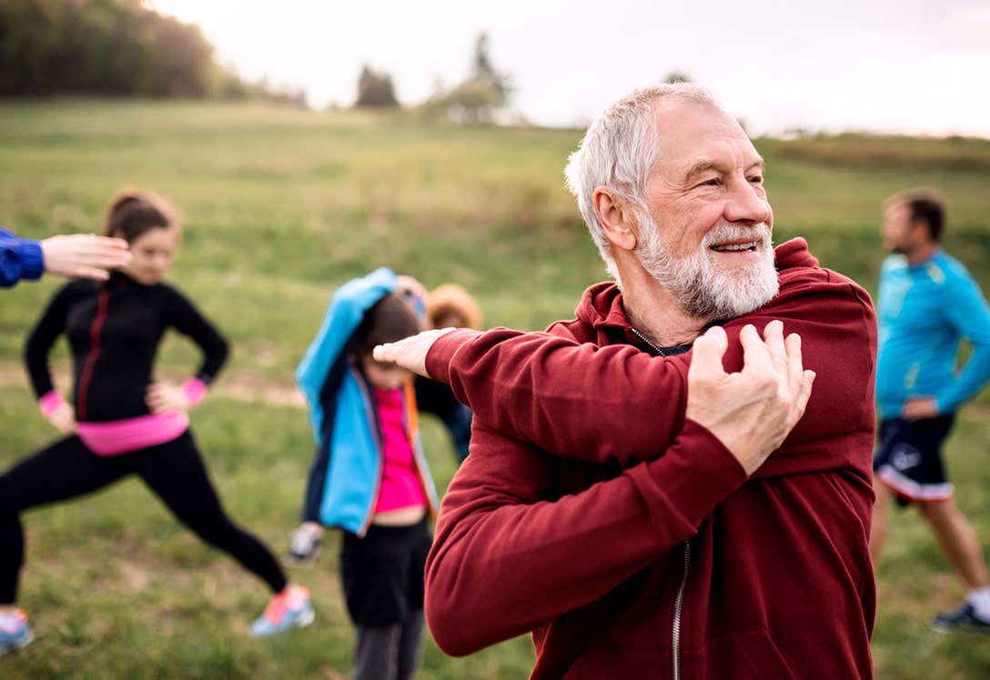 hombre mayor haciendo ejercicio al aire libre para la movilidad de las artilaciones