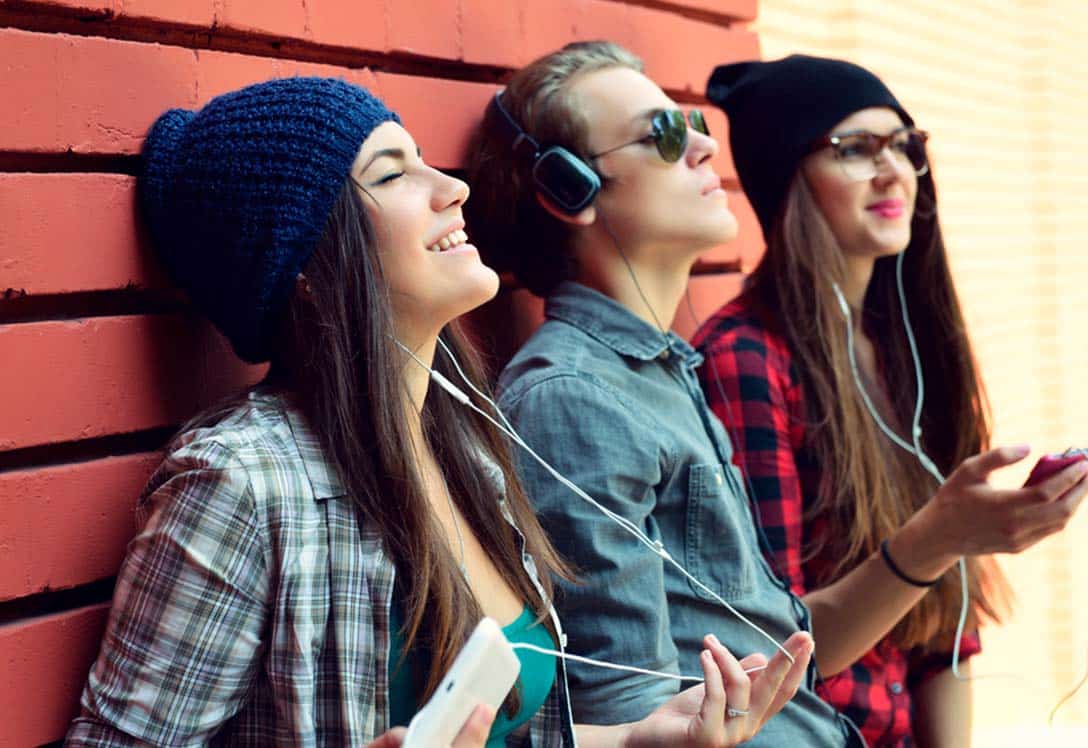 Jóvenes escuchan música con auriculares