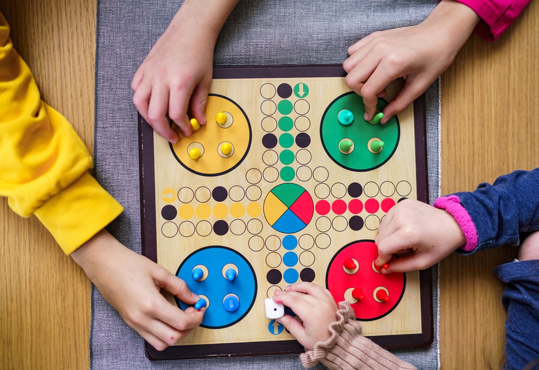 manos posicionadas jugando en tablero de parchis