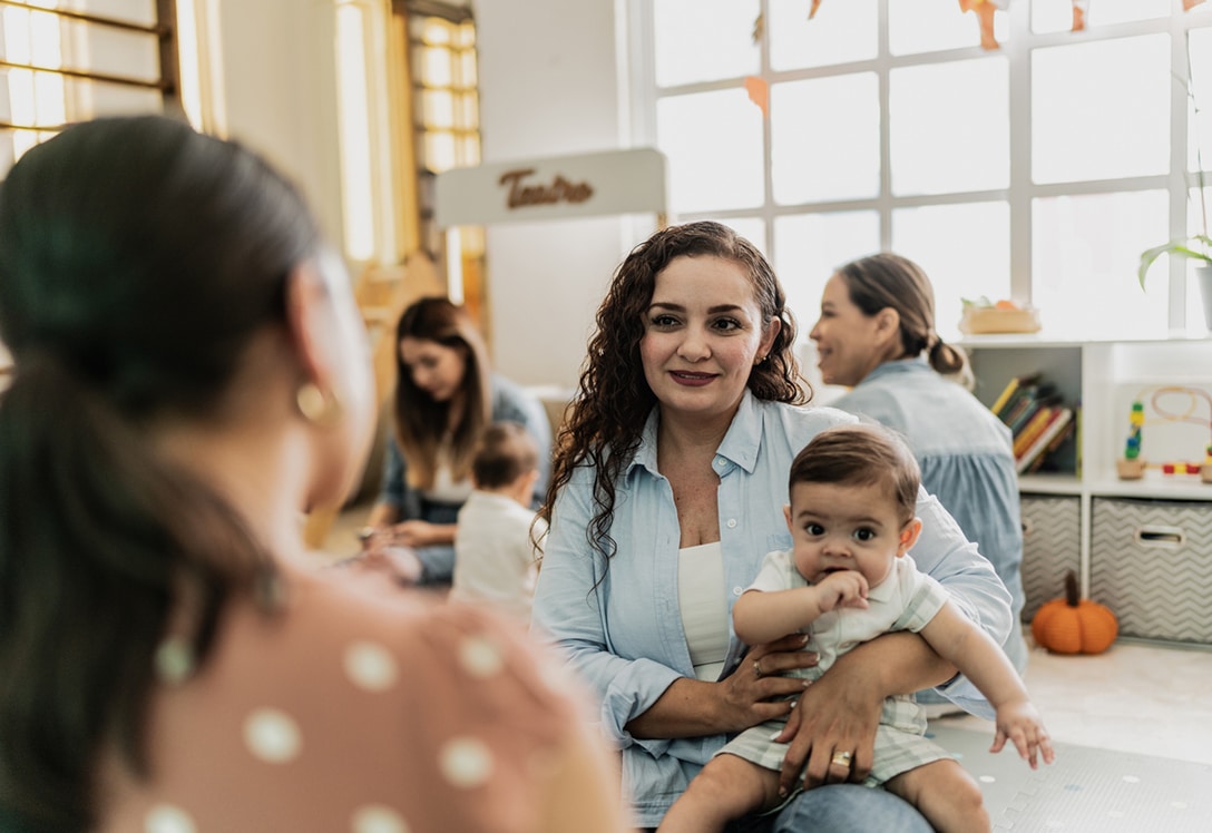 madre con su hijo hablando con profesora de la guardería