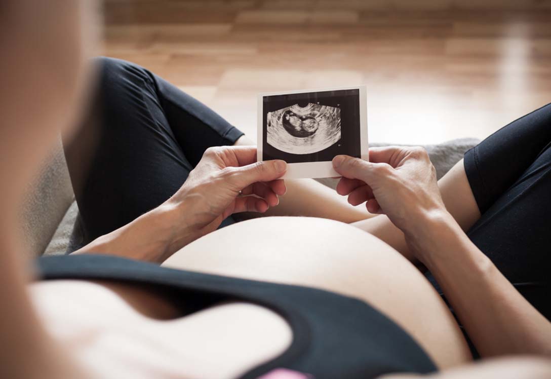 Embarazada observa ecografía del bebé