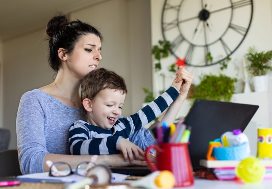 Madre teletrabajando con su hijo en casa