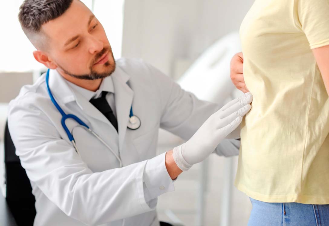 Un médico revisa el abdomen de un paciente
