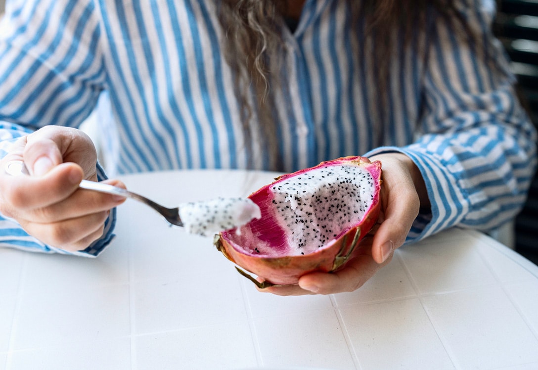 mujer comiendo fruta del dragón