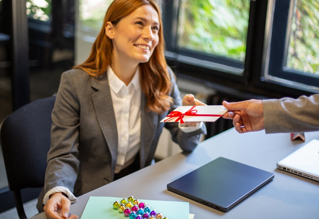 mujer-recibe-tarjeta-regalo-contenido mujer recibe una tarjeta regalo auq le permitira ahorrar con los tréboles de Club Mapfre