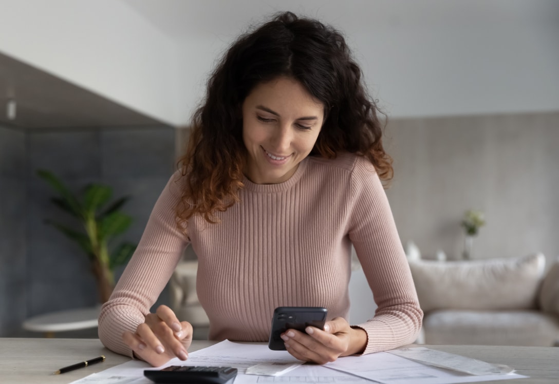 mujer-revisa-movil-cuentas-ahorro Mujer revisa el móvil para sus cuentas de ahorro