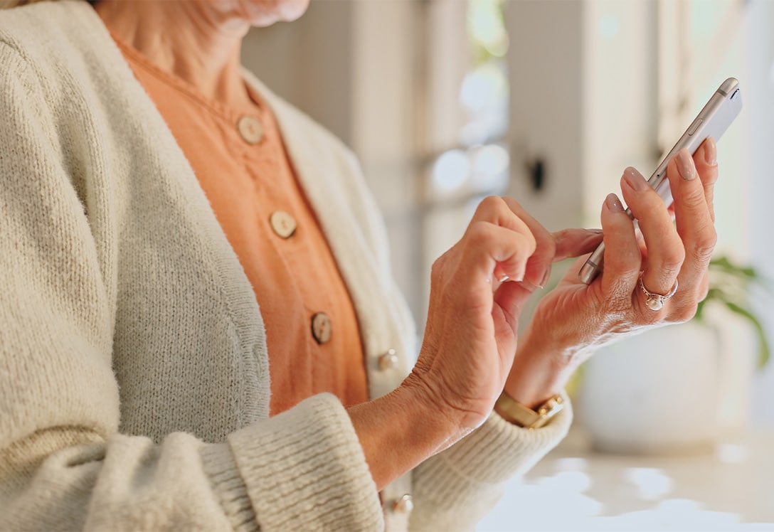 mujer mayor realiza compra segura con su teléfono movil