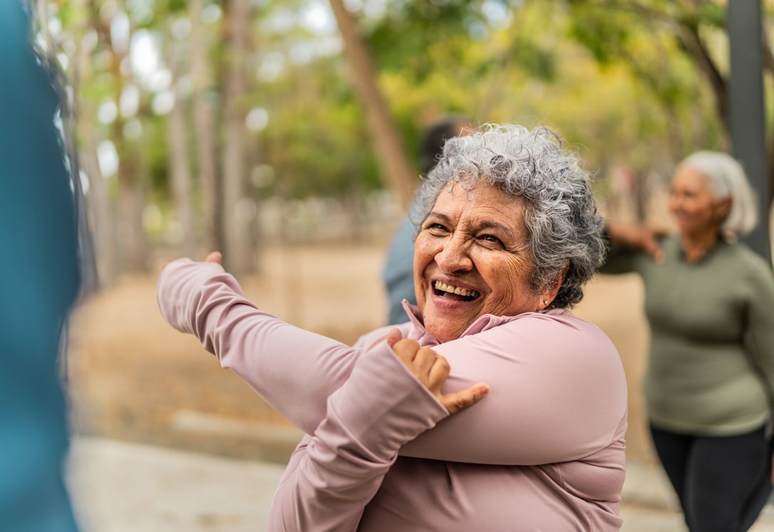 mujer mayor practica estiramientos en el parque