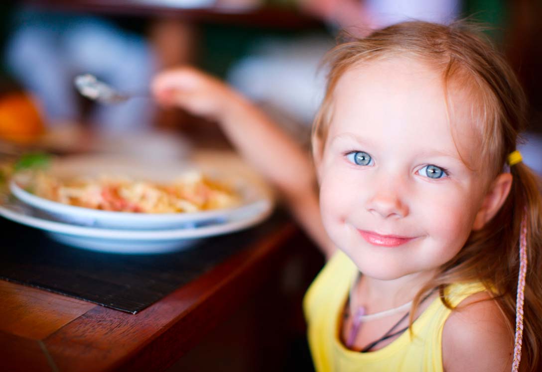 Niña comiendo plato de pasta