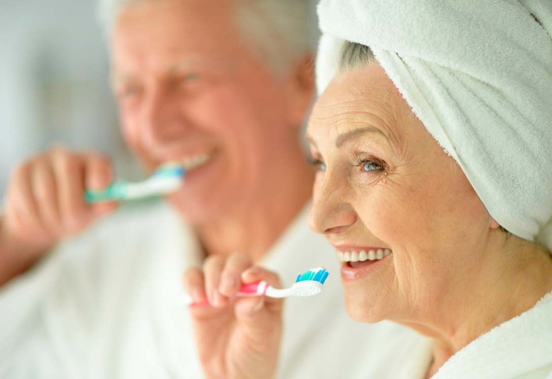 pareja-adultos-mayores Pareja de adultos mayores cepillando los dientes