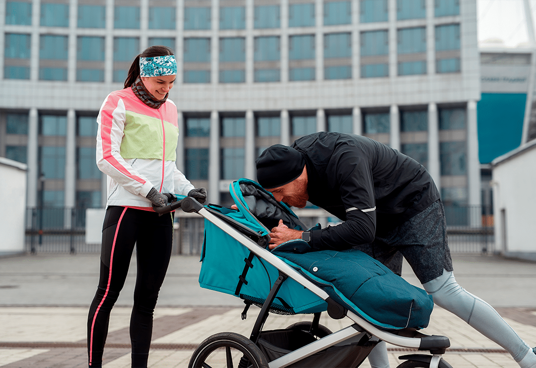 pareja deportista con carrito de bebe