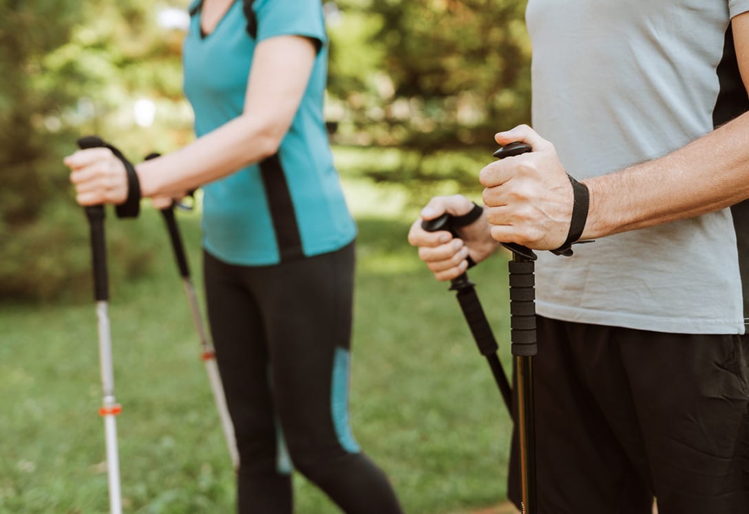 pareja practica marcha nórdica en el campo