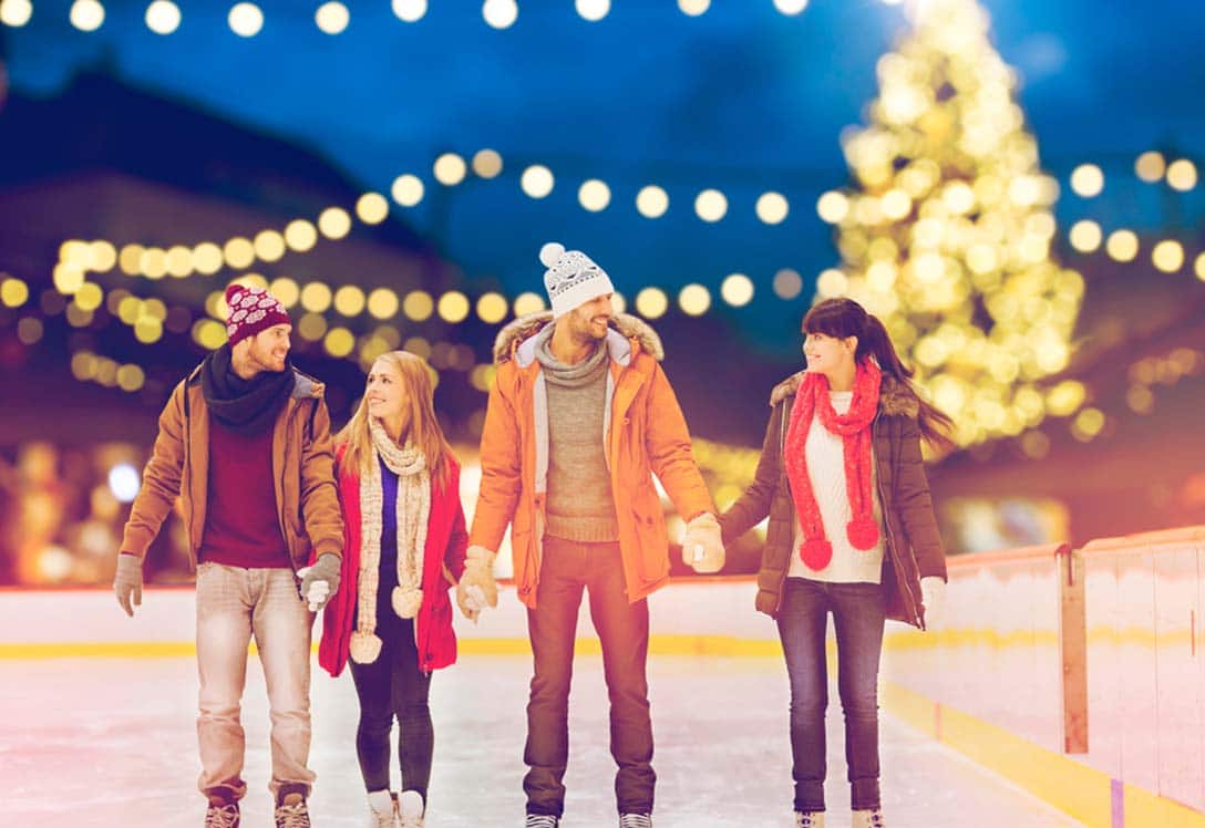 Parejas patinando en el hielo durante la navidad