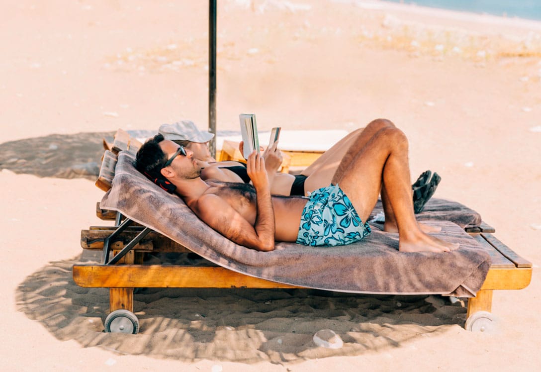 Pareja leyendo en la playa