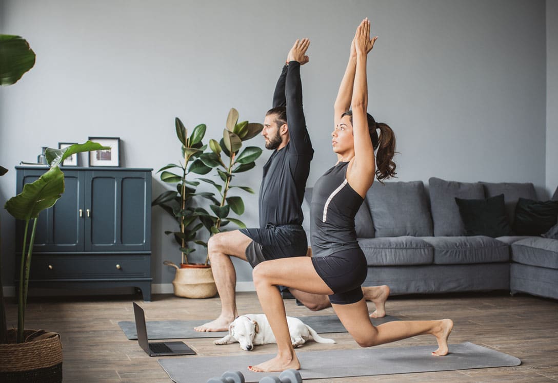 pareja practicando pilates y yoga en casa