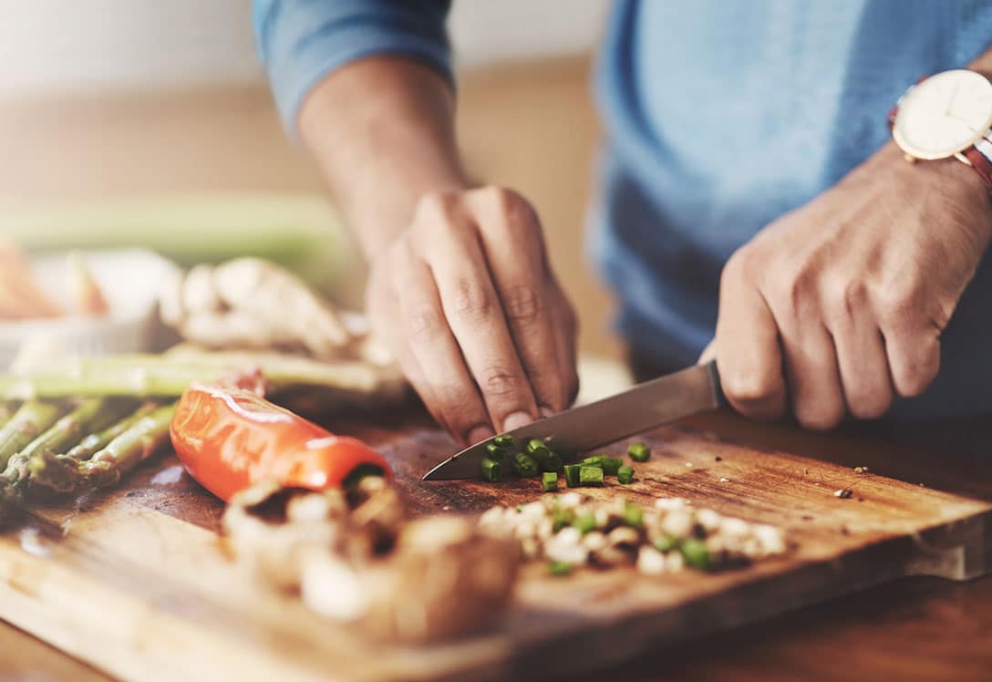 persona cortando vegetales en una tabla