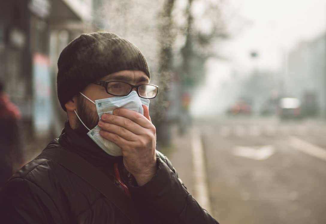 Persona con mascarilla por alto nivel de contaminación