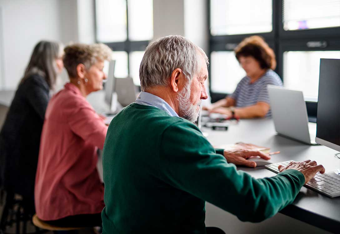 mayores realizando un curso de competencias digitales