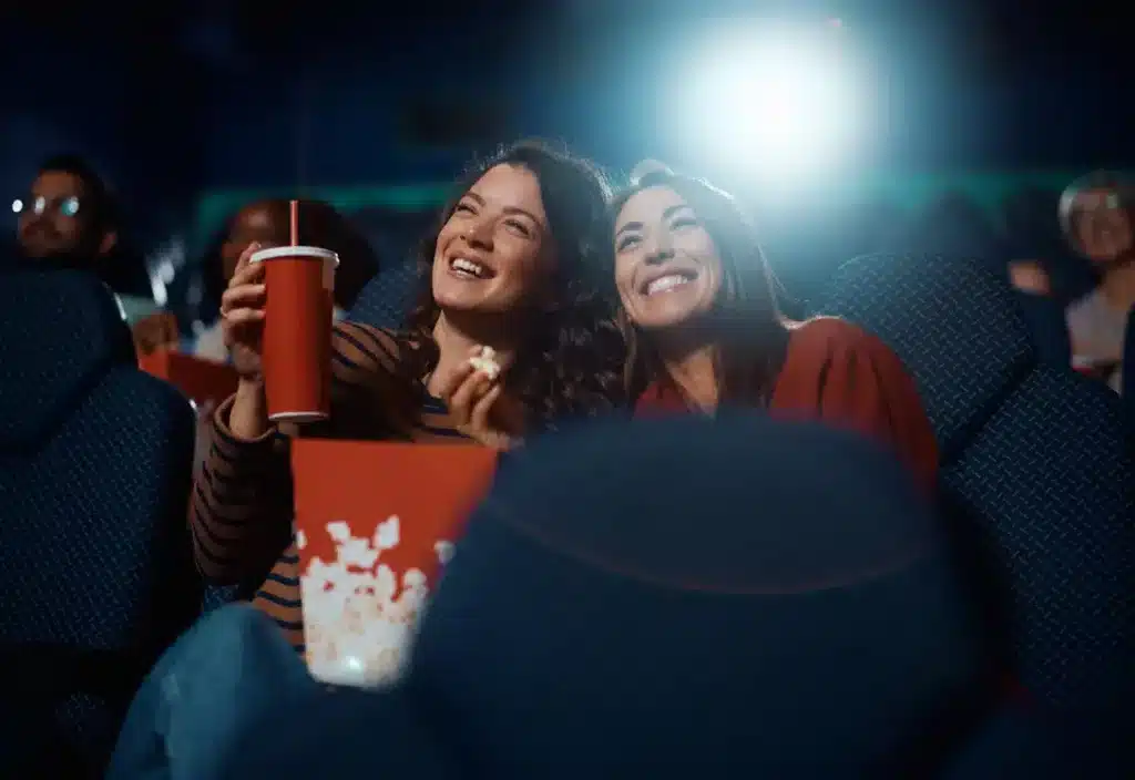 mujeres en una sala de cine con palomitas y refesco